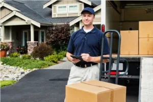 Professional mover in front of an open moving truck