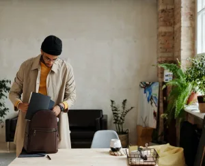 Man putting away notebooks and preparing to pack an office