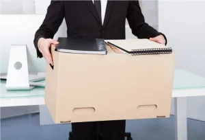 Person in a suit holding a moving box