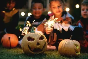 Cleveland Fall Activities children carving Halloween pumpkins and holding sparklers